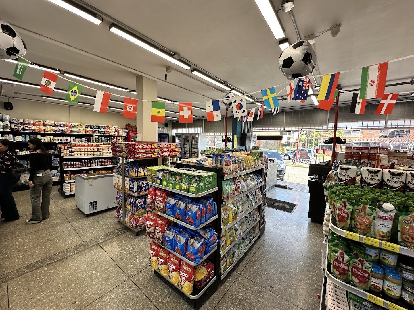 Pasillos de El Triunfo Supermarket con producto y banderines